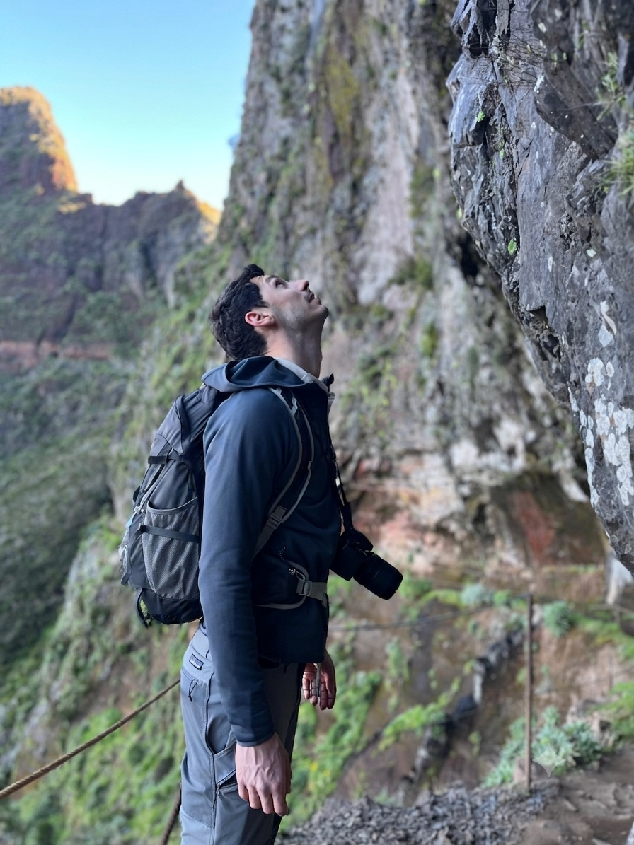 Mirko Tosoni looking up at mountain cliffs